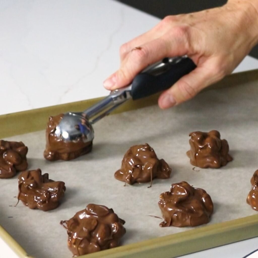 Scooping peanut clusters onto wax paper 