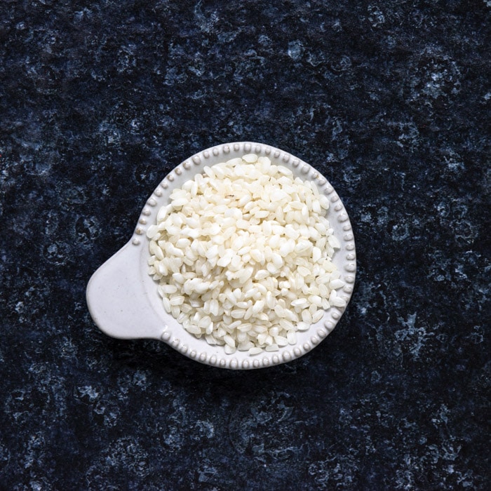 Arborio rice, short grain Italian rice in a white bowl, used in risotto recipes