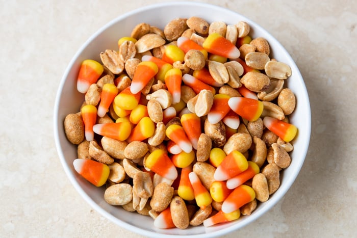 Sweet and salty candy corn snack mix in a white bowl