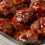 Ham Balls baked in a brown sugar and tomato sauce in a glass baking dish