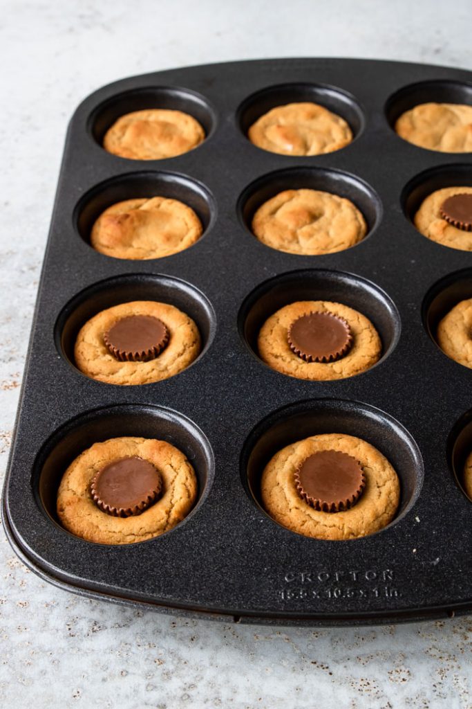 muffin pan with peanut butter cup cookies inside