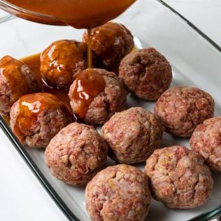 pouring the tomato brown sugar sauce over the ham balls