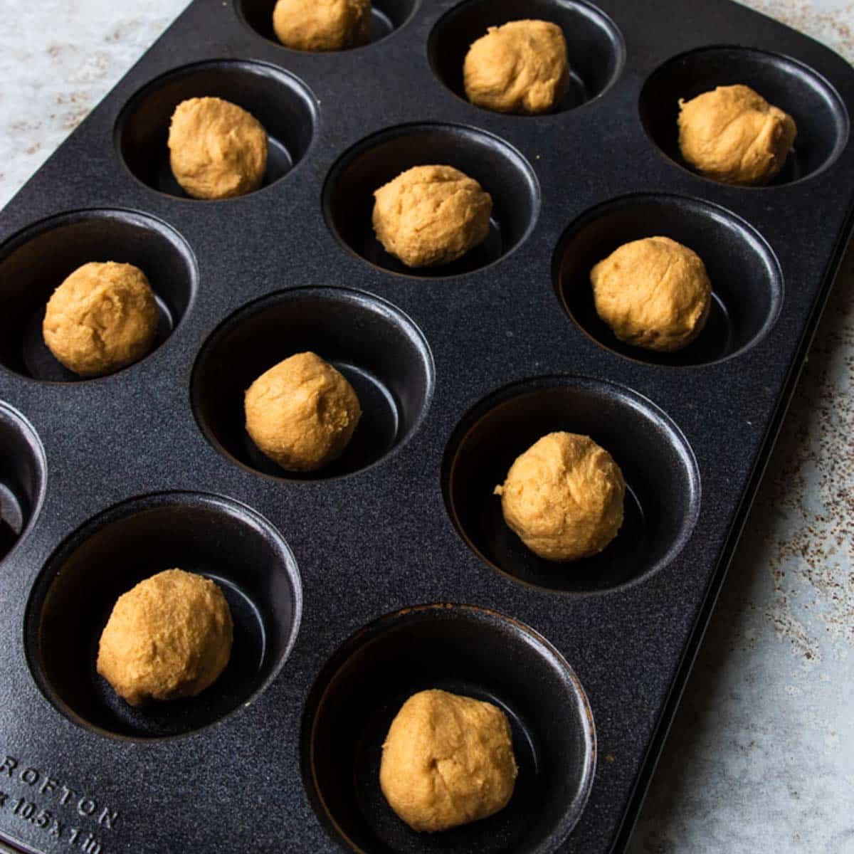 peanut butter cookie balls in a muffin tin