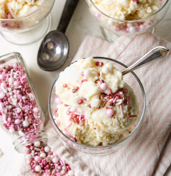 snow ice cream in a glass dessert bowl topped with pink and white sprinkles