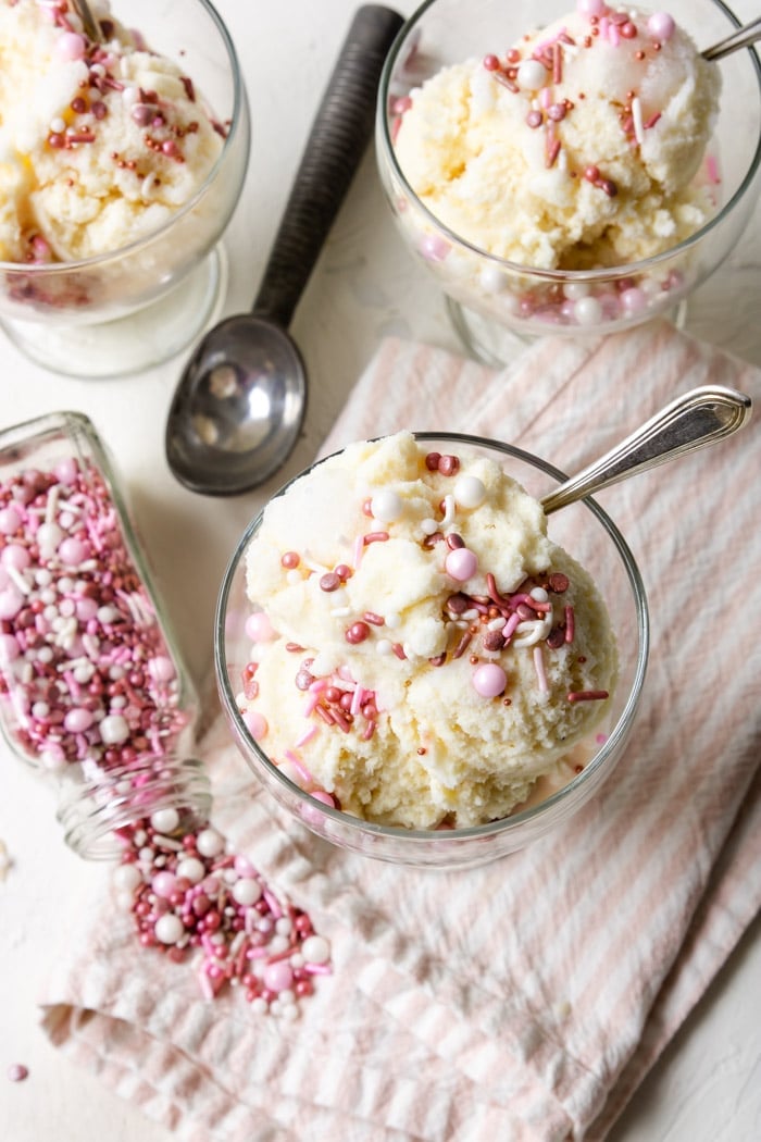 snow ice cream in a glass dessert bowl topped with pink and white sprinkles