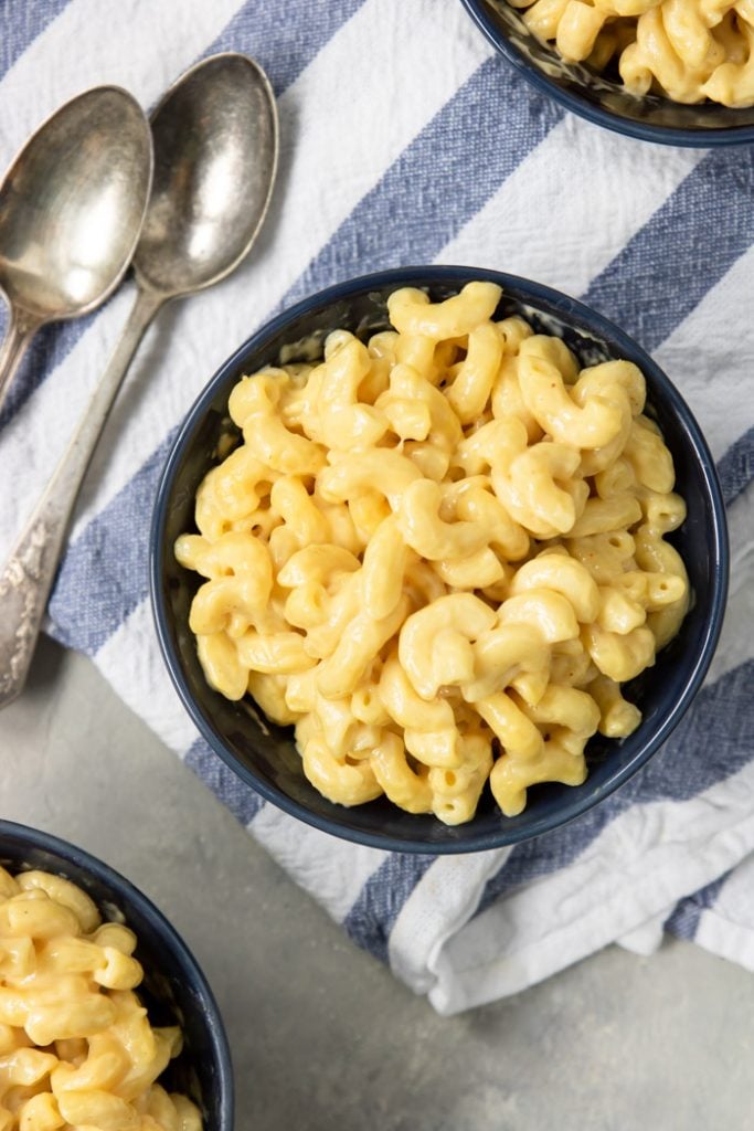 Instant Pot Mac and Cheese in a blue bowl on top of a striped napkin