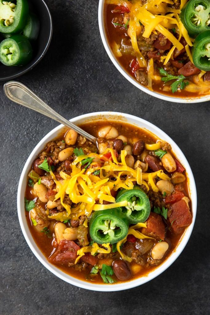 Instant Pot Chili in a bowl topped with cheese and jalapenos