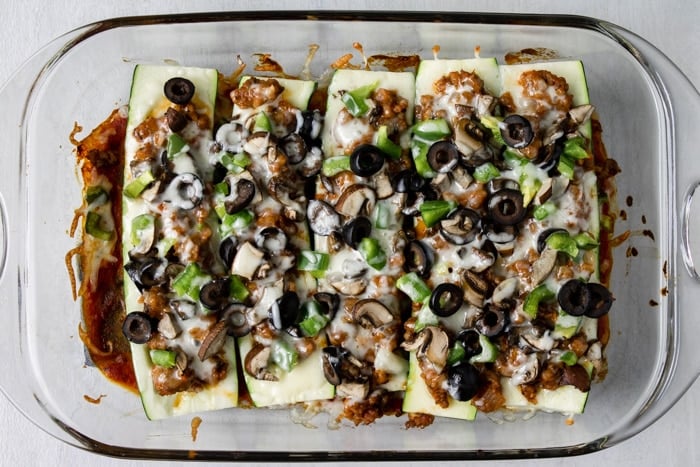 baked zucchini pizza boats in a glass casserole dish