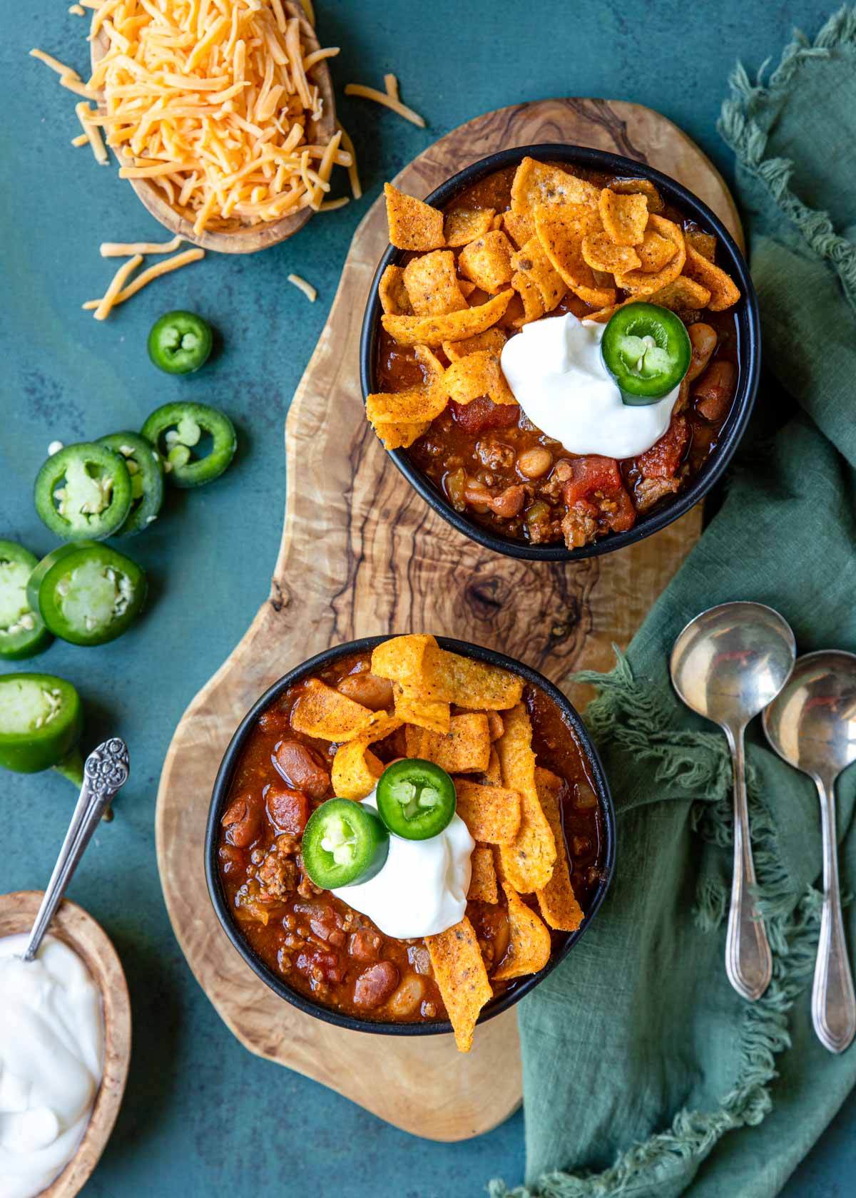 Instant Pot Chili in two bowls topped with cheese, sour cream and fritos
