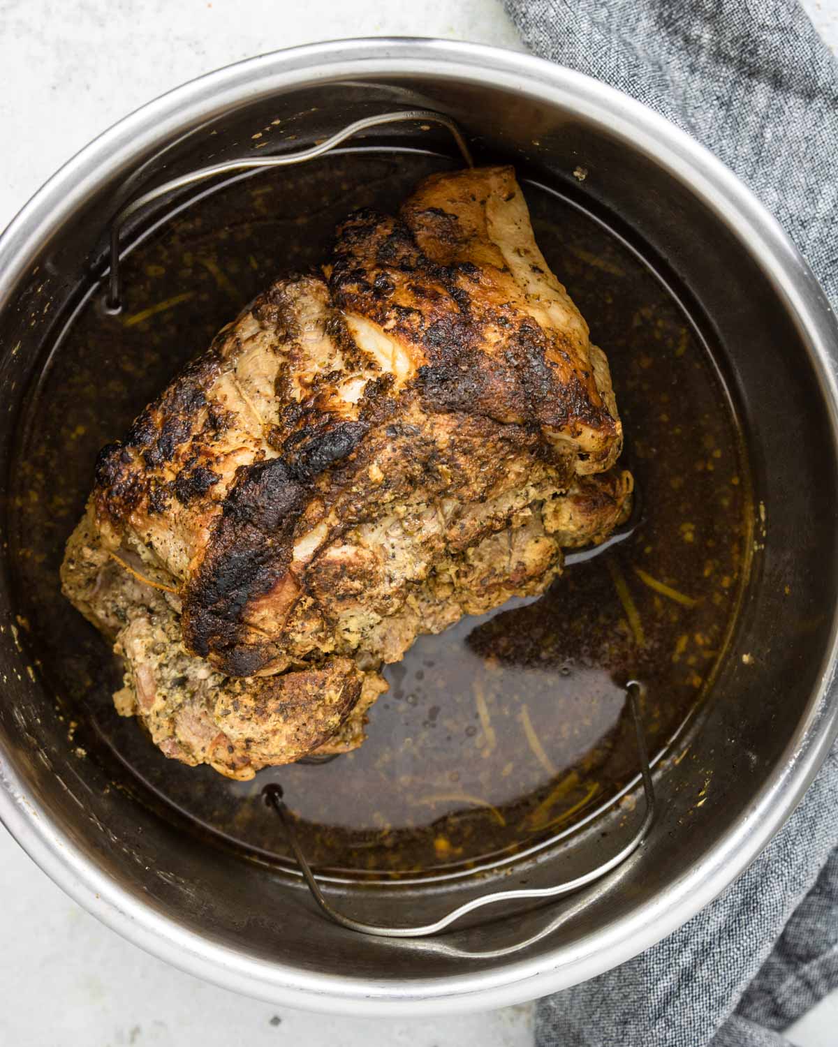 a pork roast that has been browned and is in the Instant Pot to be cooked