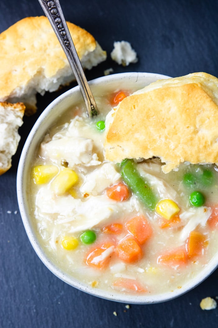 up close picture of chicken stew with a biscuit on top