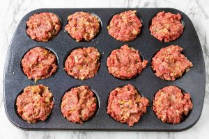 muffin tin filled with meatloaf mixture