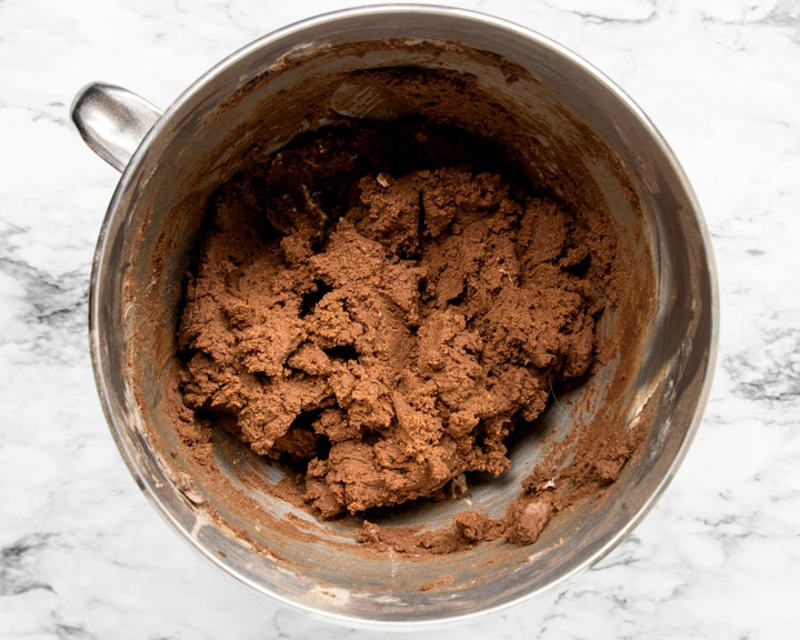 Chocolate cookie dough for Rolo Cookies in a stand mixer bowl