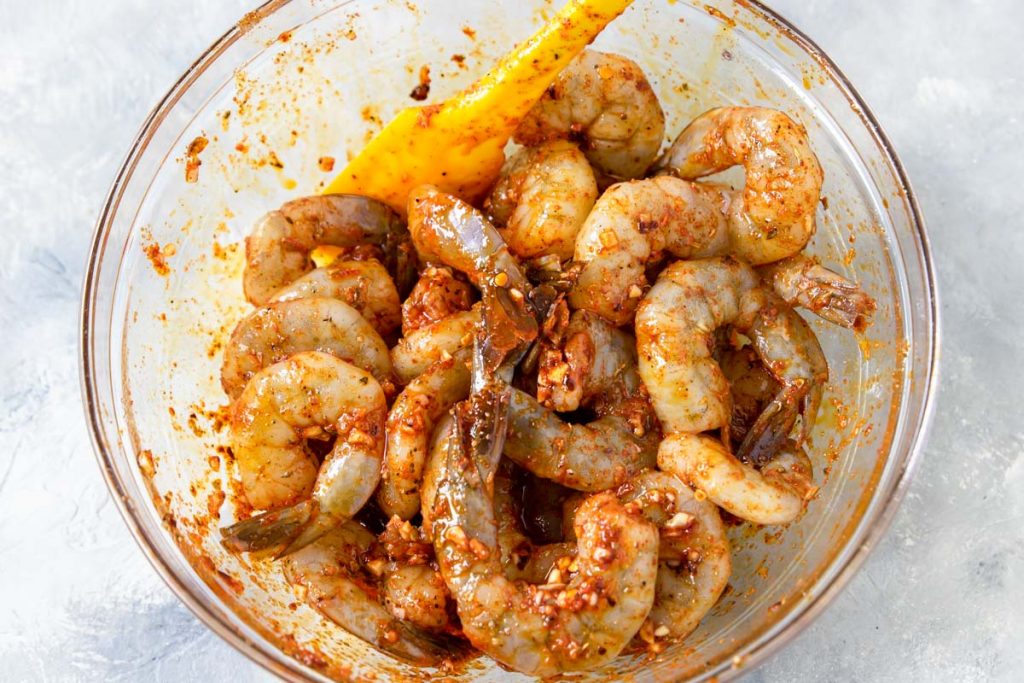 raw shrimp marinating in a cajun marinade