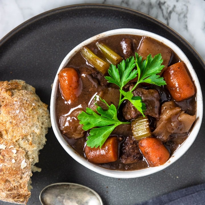 one bowl of red wine beef stew garnished with parsley