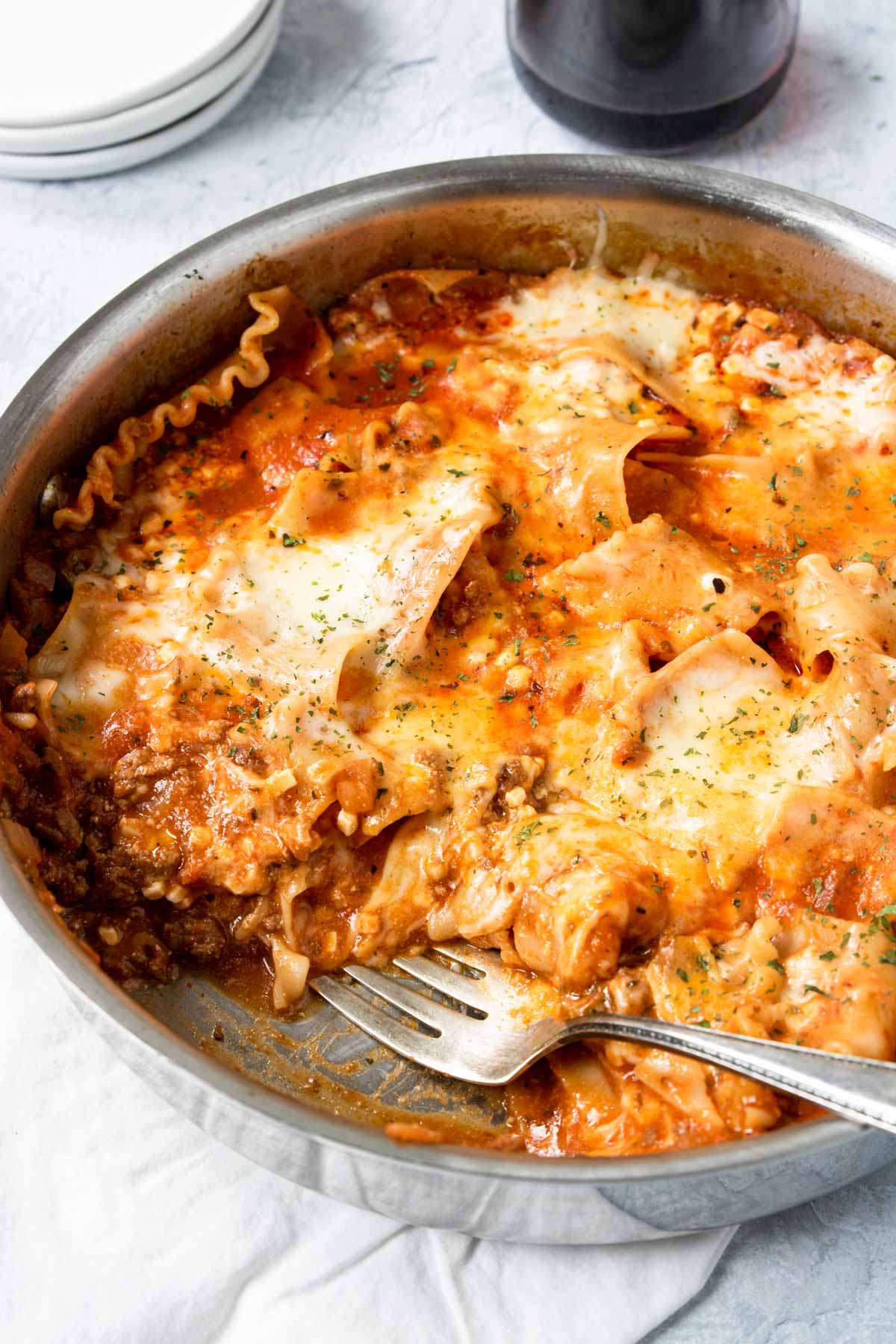 Close up of skillet lasagna with a piece taken out