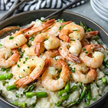 Instant Pot Shrimp Risotto in a grey bowl with a black and white napkin to the side