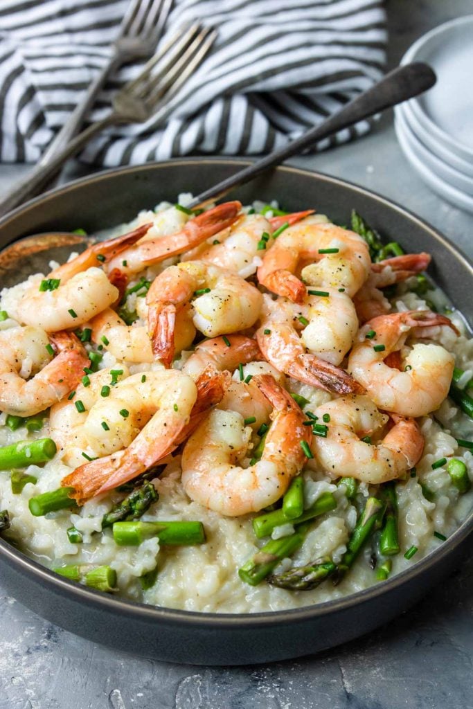 Instant Pot Shrimp Risotto in a grey bowl with a black and white napkin to the side