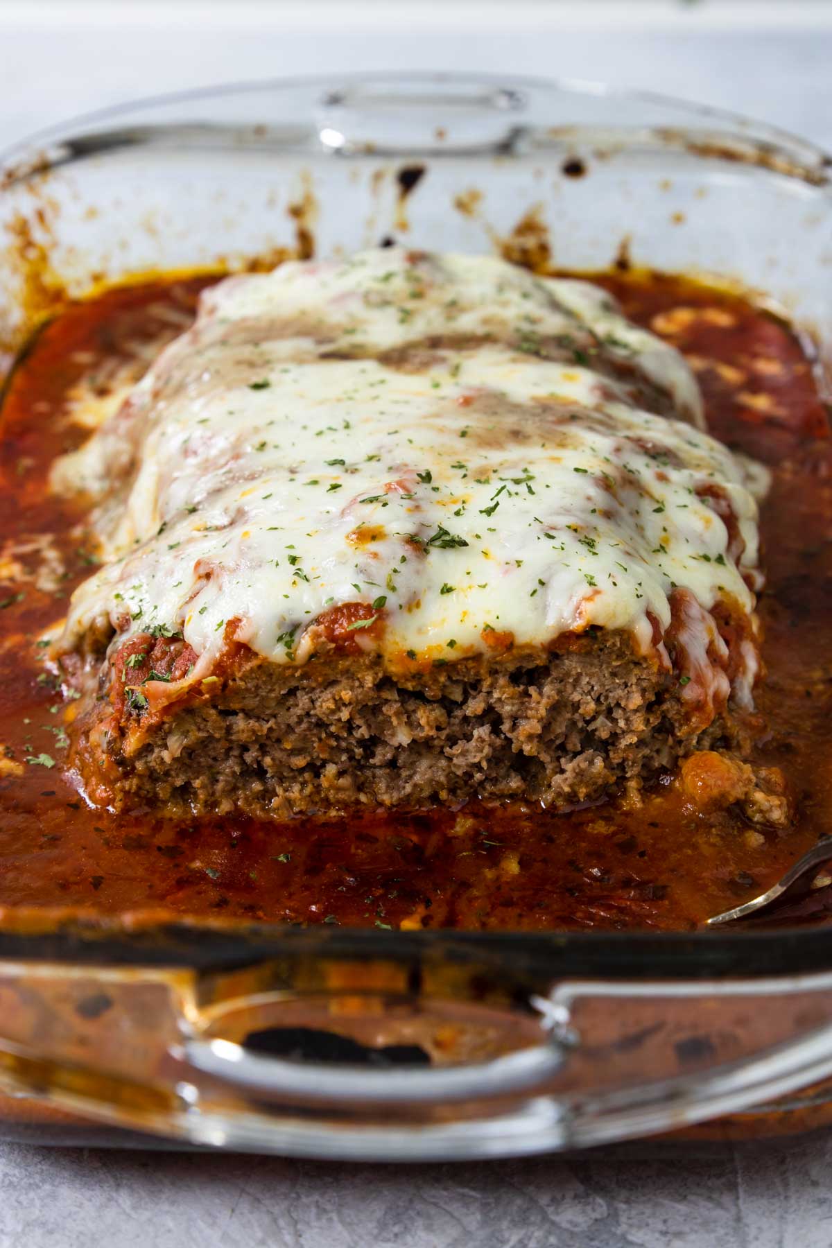 Italian Meatloaf in a baking dish topped with cheese