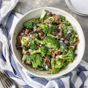 a large white bowl with a broccoli salad with bacon