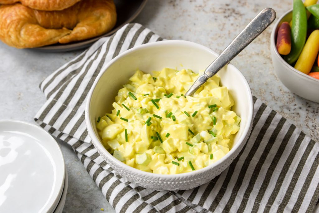 easy egg salad recipe in a white bowl with a spoon