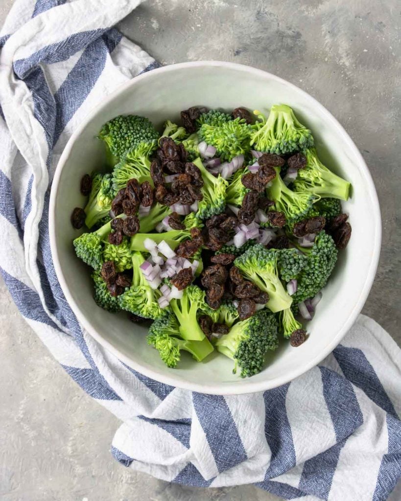 broccoli, onions, and raisins in a bowl
