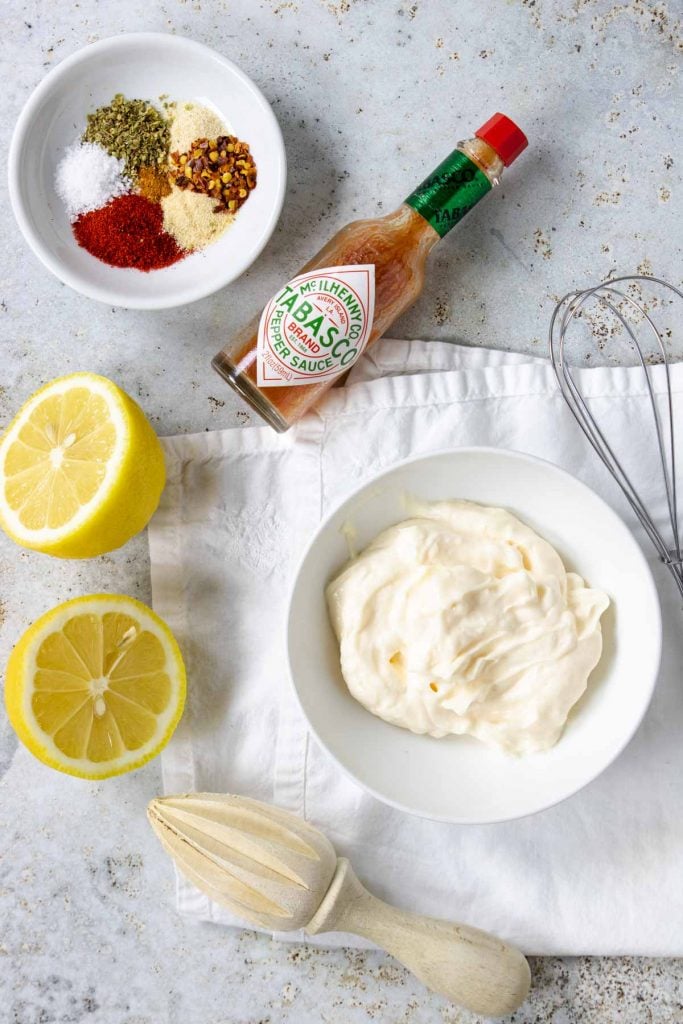 Ingredients for cajun aioli - spices, mayo, lemon, hot sauce