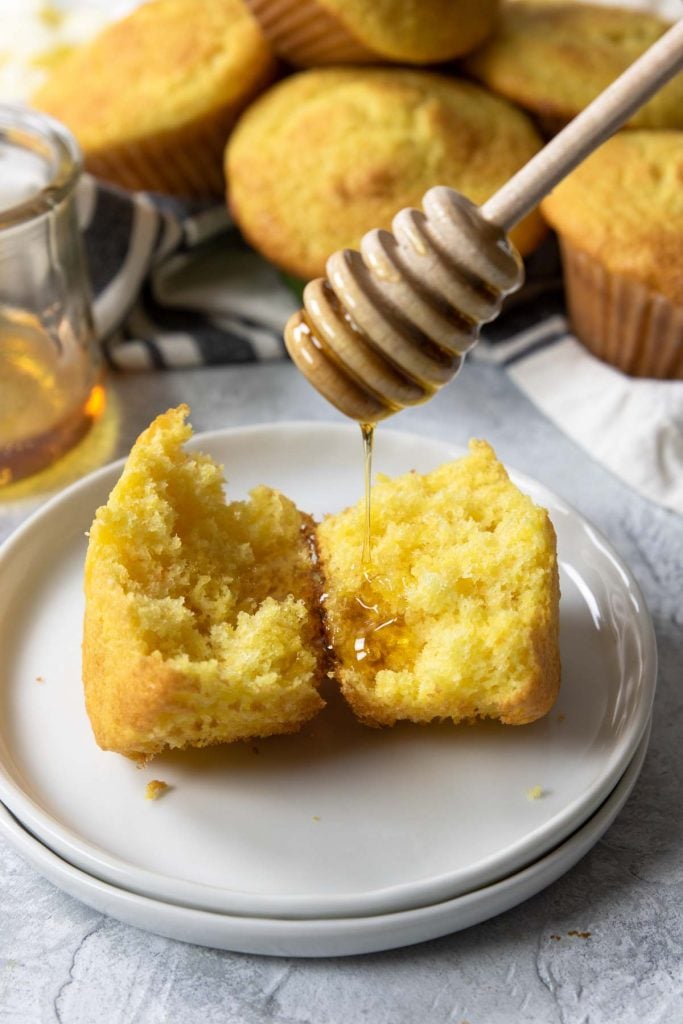 honey being drizzled on a corn muffin