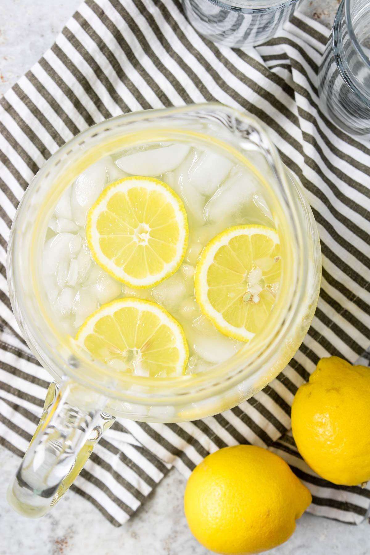 overhead photo of a pitcher of lemonade with 3 lemon wheels