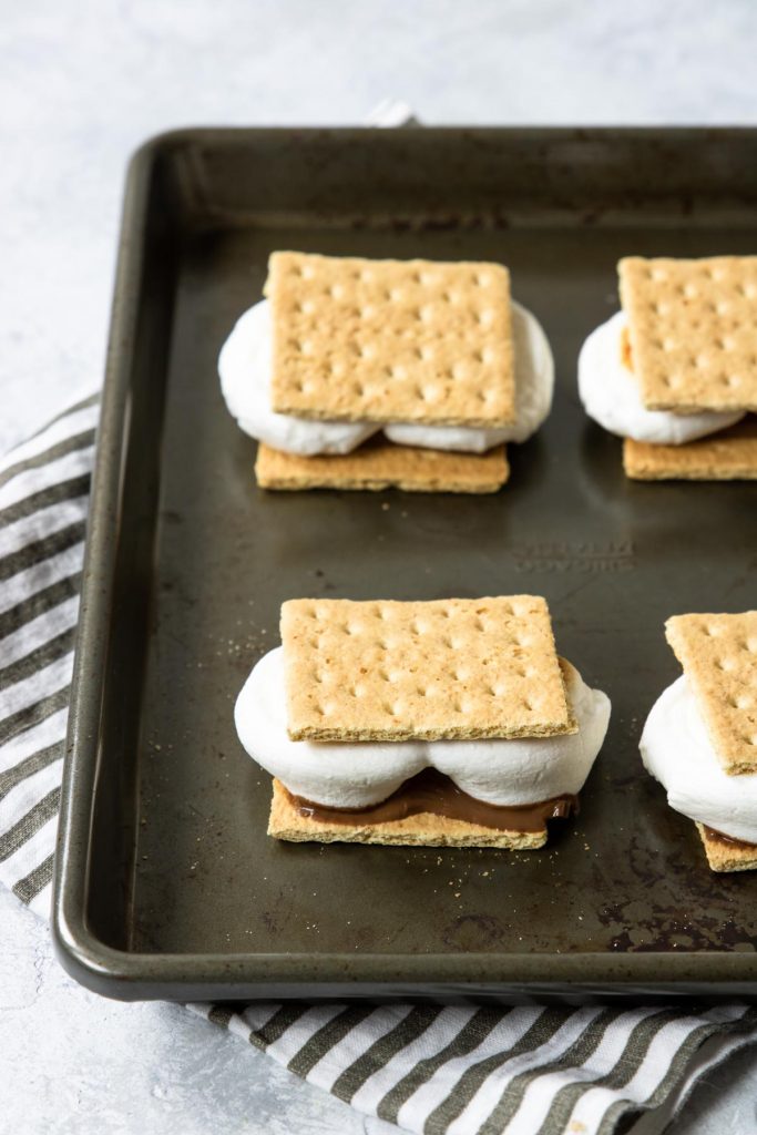 Placing the top graham cracker on the oven s'mores