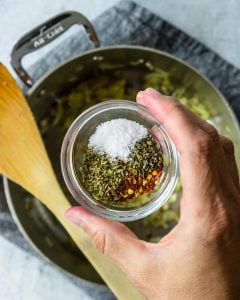 A small bowl of seasoning - basil, oregano, salt, and red pepper flakes