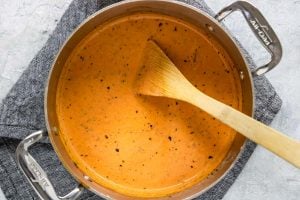 Tomato Cream Sauce in a pot with a wooden spoon