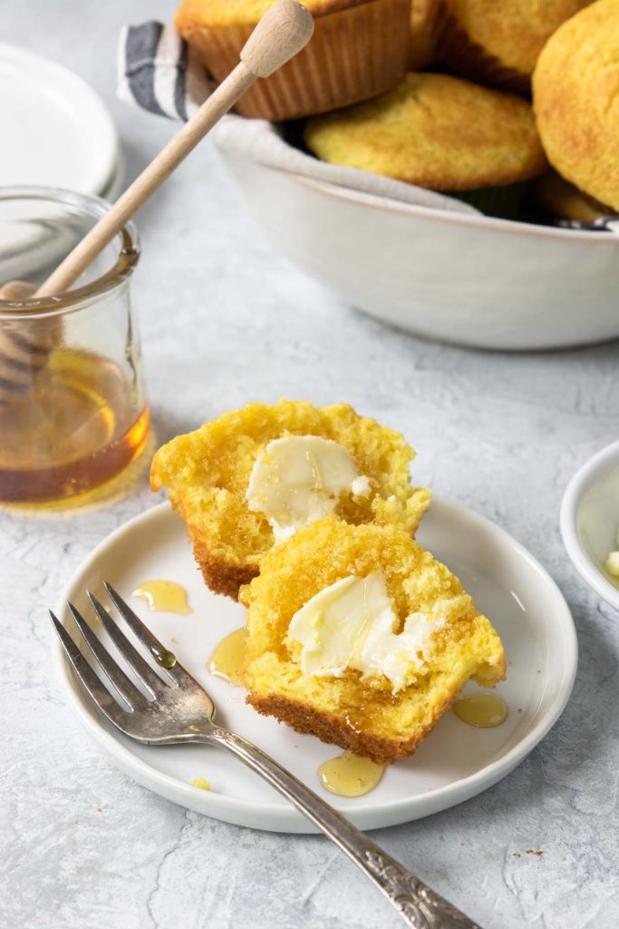 cornbread muffins on a plate with butter and honey