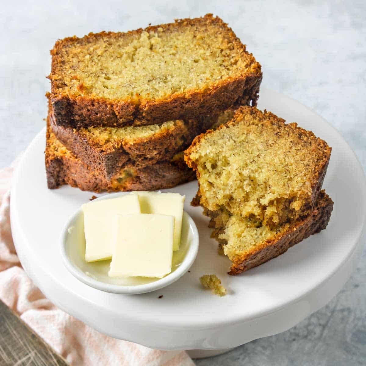 three slices of banana bread on a plate with butter