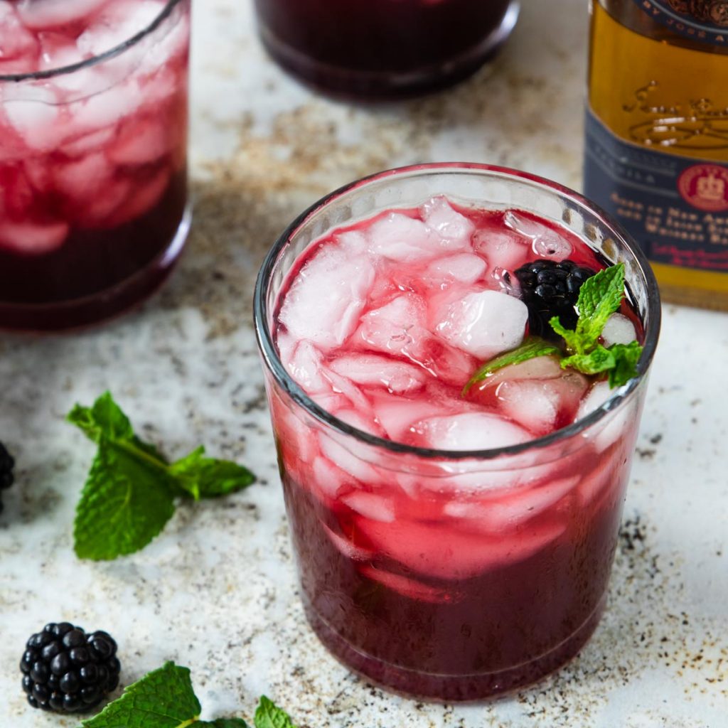 Blackberry smash cocktail in a glass with mint and blackberries
