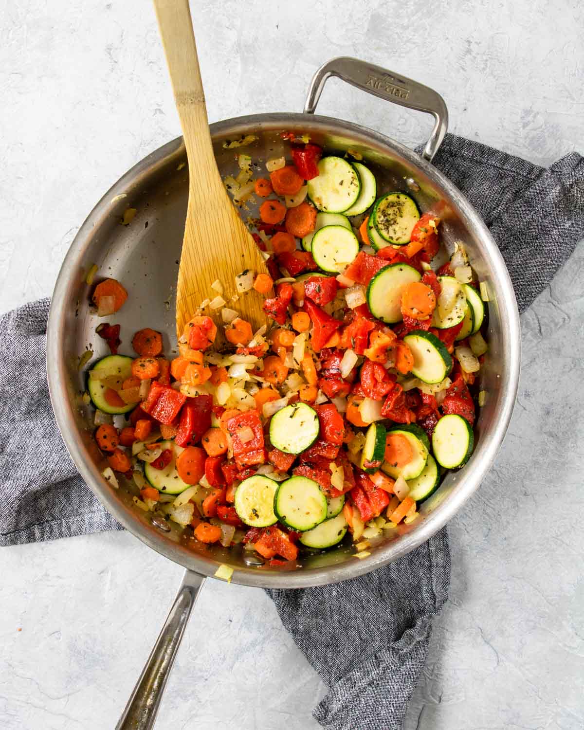 saute pan with carrots, onions, zucchini, roasted red peppers, and garlic