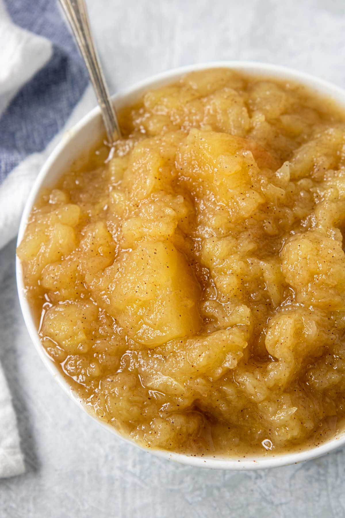homemade applesauce in a white bowl with a spoon