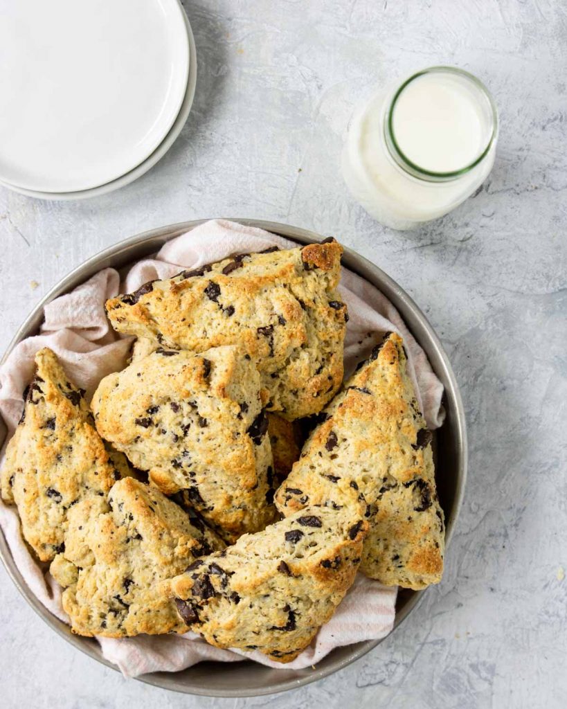 a jug of milk and a basket of chocolate chip scones