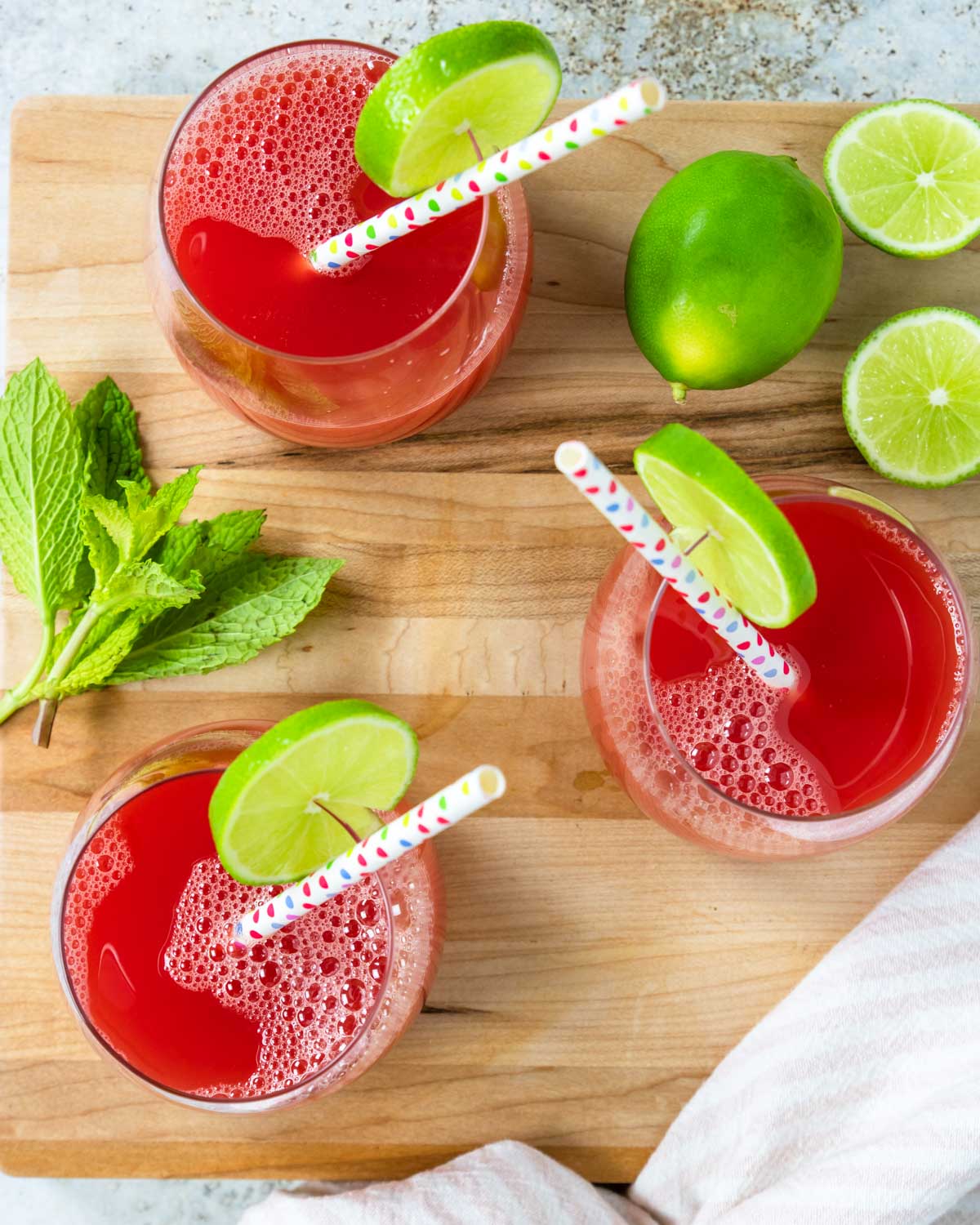 three glasses of watermelon juice from above garnished with limes