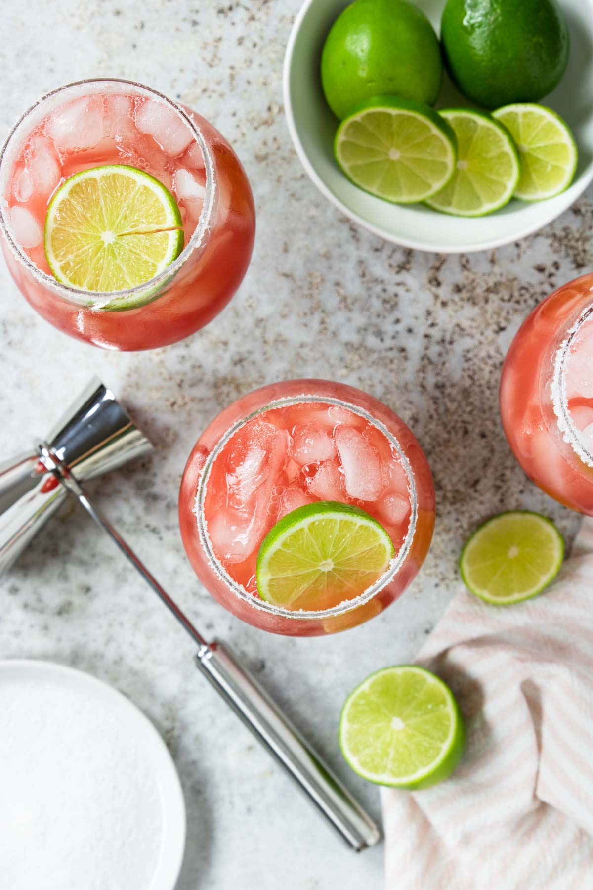 watermelon margaritas photographed from above showing the drink in the glass and a bowl of limes