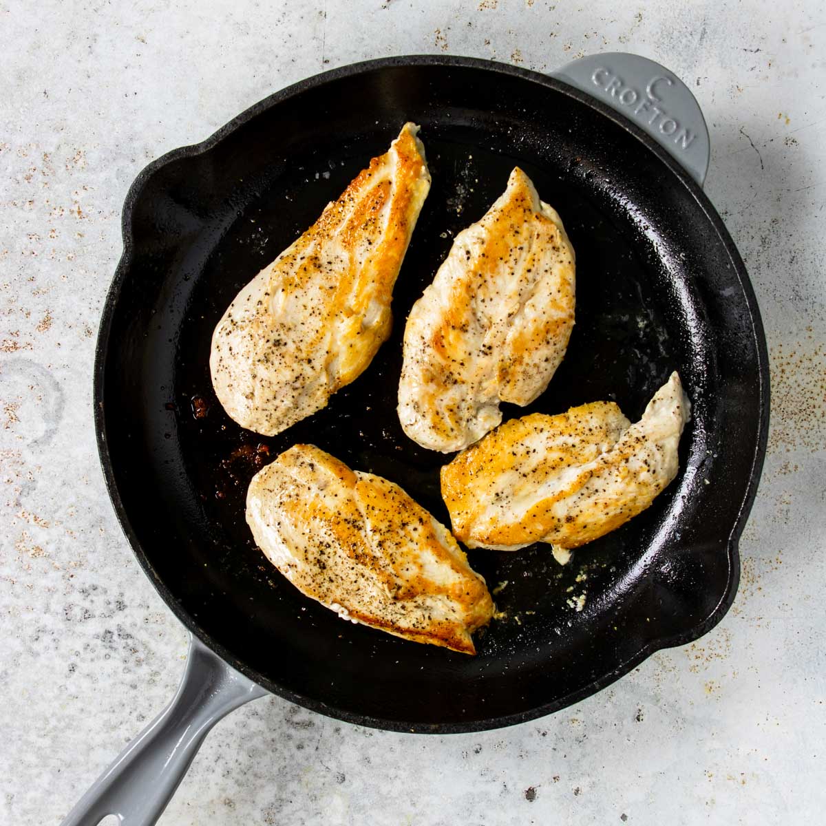 4 cooked chicken breasts in a skillet