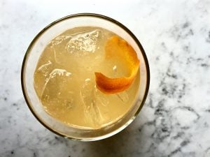 Orange Rosemary Cocktail in a glass with an orange peel