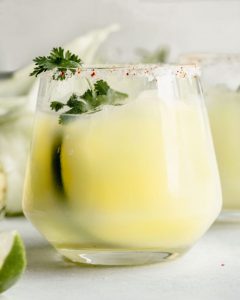 sweet corn margarita in a glass with cilantro