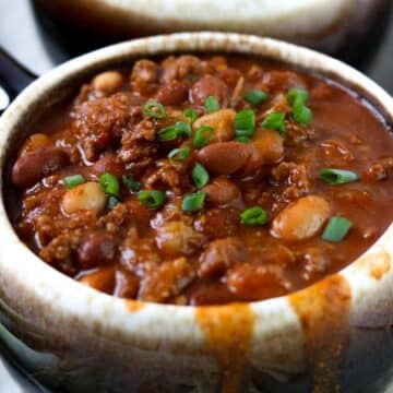 a big bowl of chili topped with green onions
