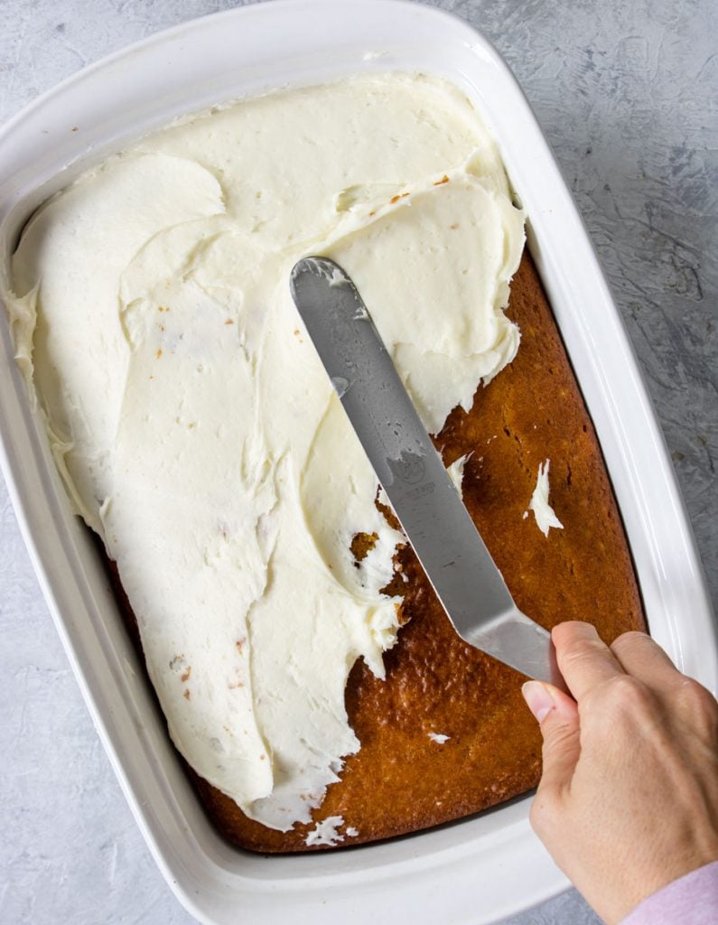 frosting pumpkin bars in a pan 