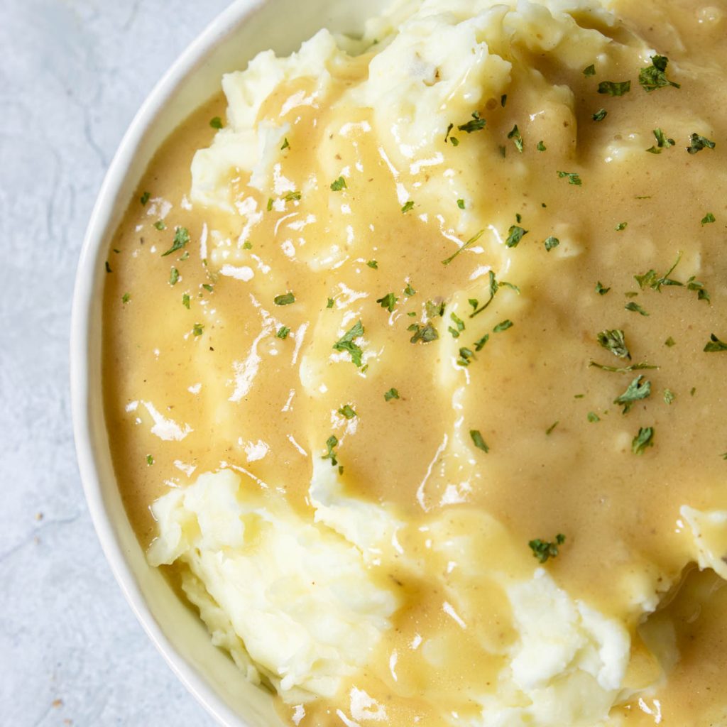 mashed potatoes topped with gravy and garnished with parsley