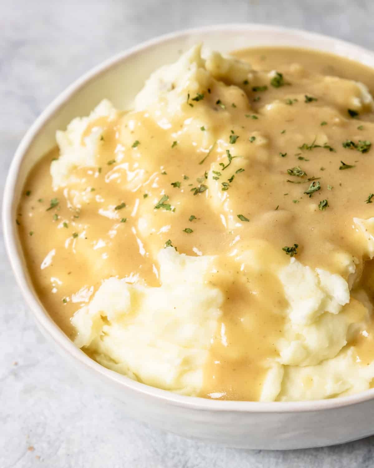 gravy poured over mashed potatoes with parsley garnish