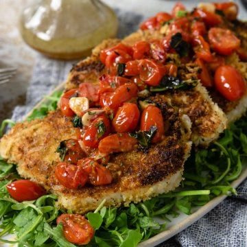 pork milanese topped with a tomato relish