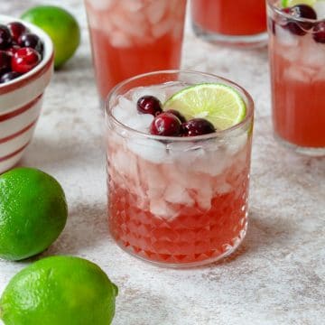 cranberry punch in a glass with cranberries and limes