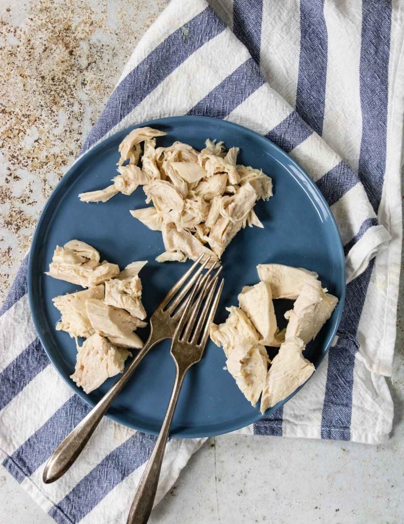 poached chicken on a plate cut three ways - shred, sliced, cubed